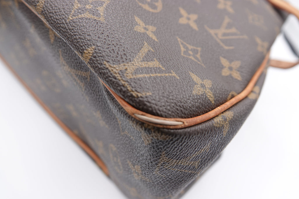 Close-up of a brown leather handbag with visible brand logo on a white background