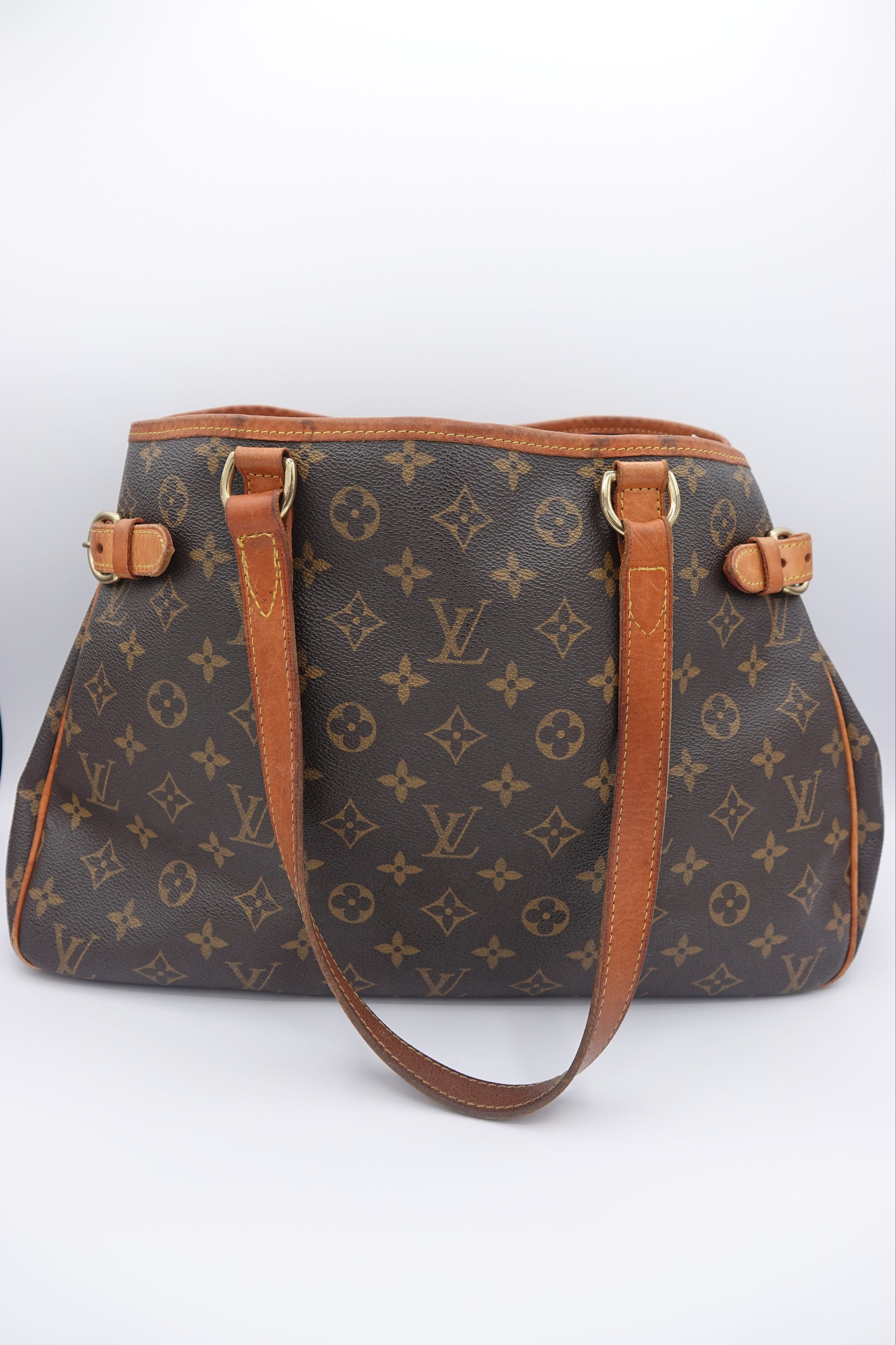 Brown patterned shoulder bag with gold accents on a white background