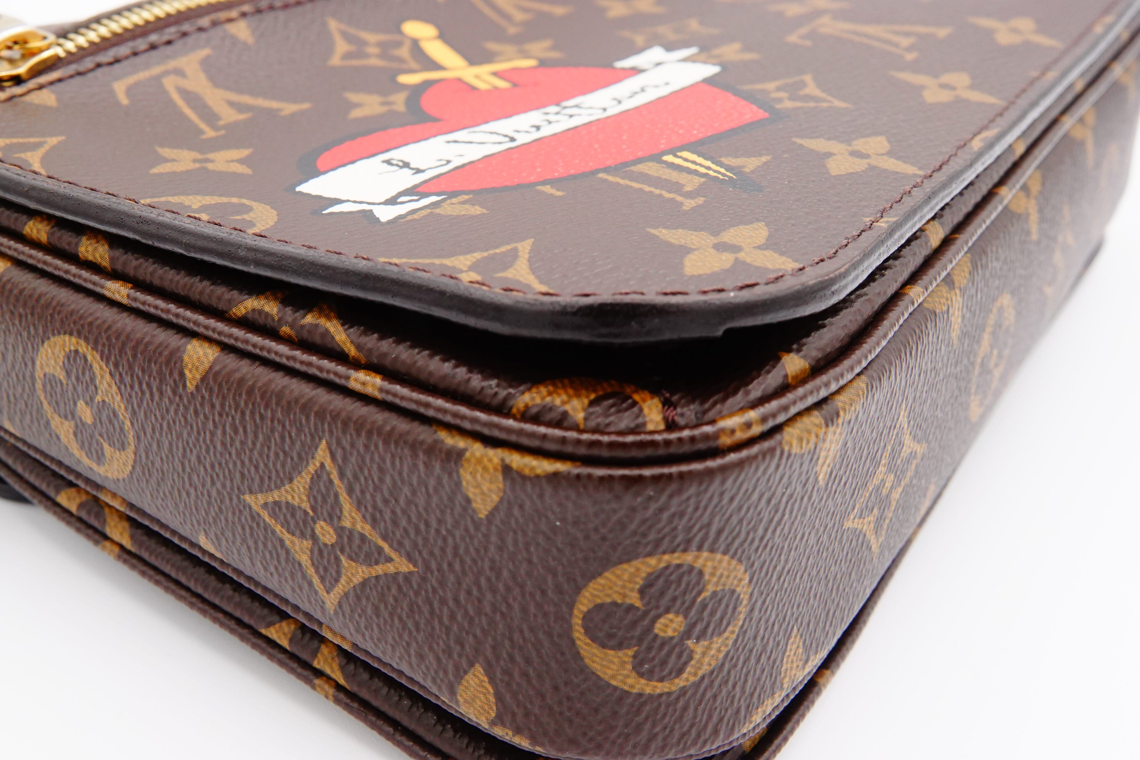 Louis Vuitton monogram handbag with a red and white emblem on a white background