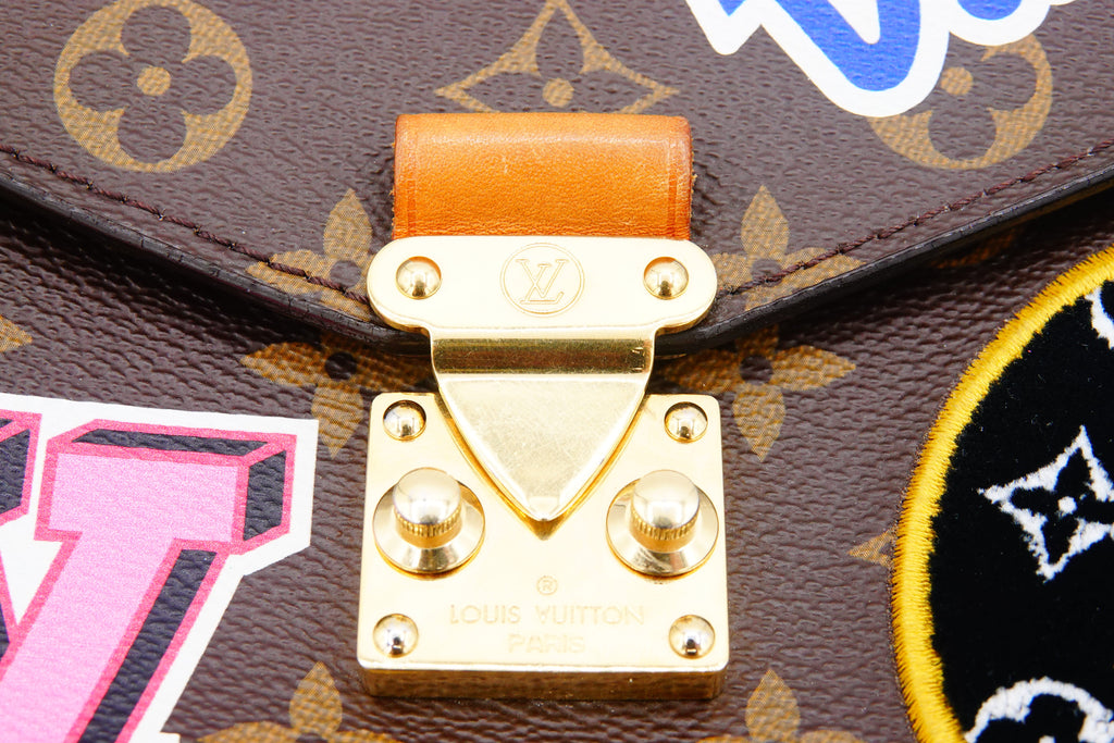 Close-up of a gold lock on a Louis Vuitton bag with brand logo.