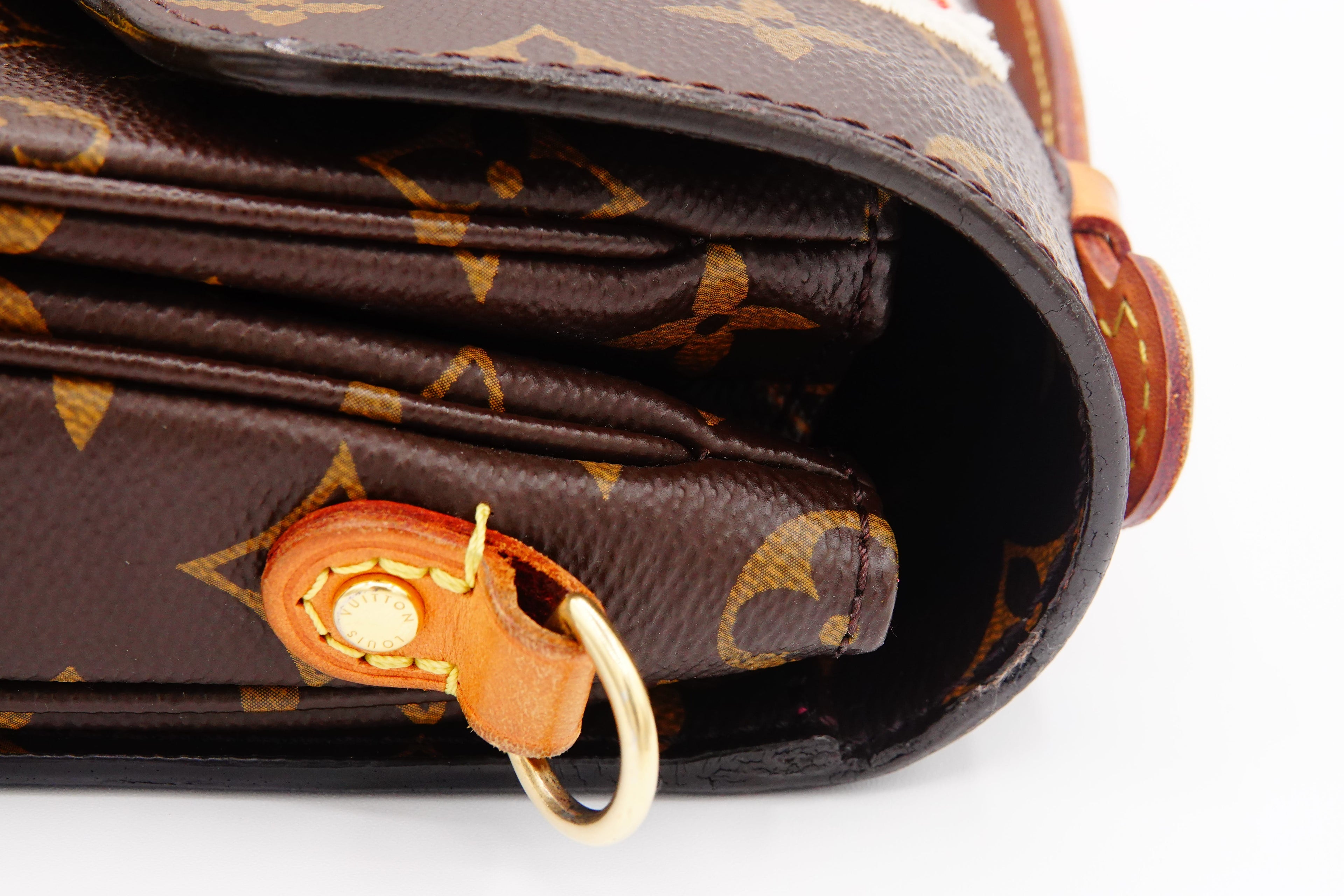 Close-up of a brown patterned wallet with a gold clasp on a white background