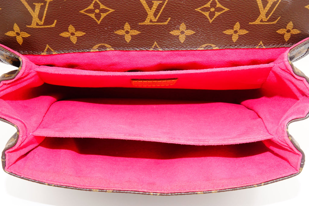 Close-up of a Louis Vuitton handbag with monogram pattern and pink interior.
