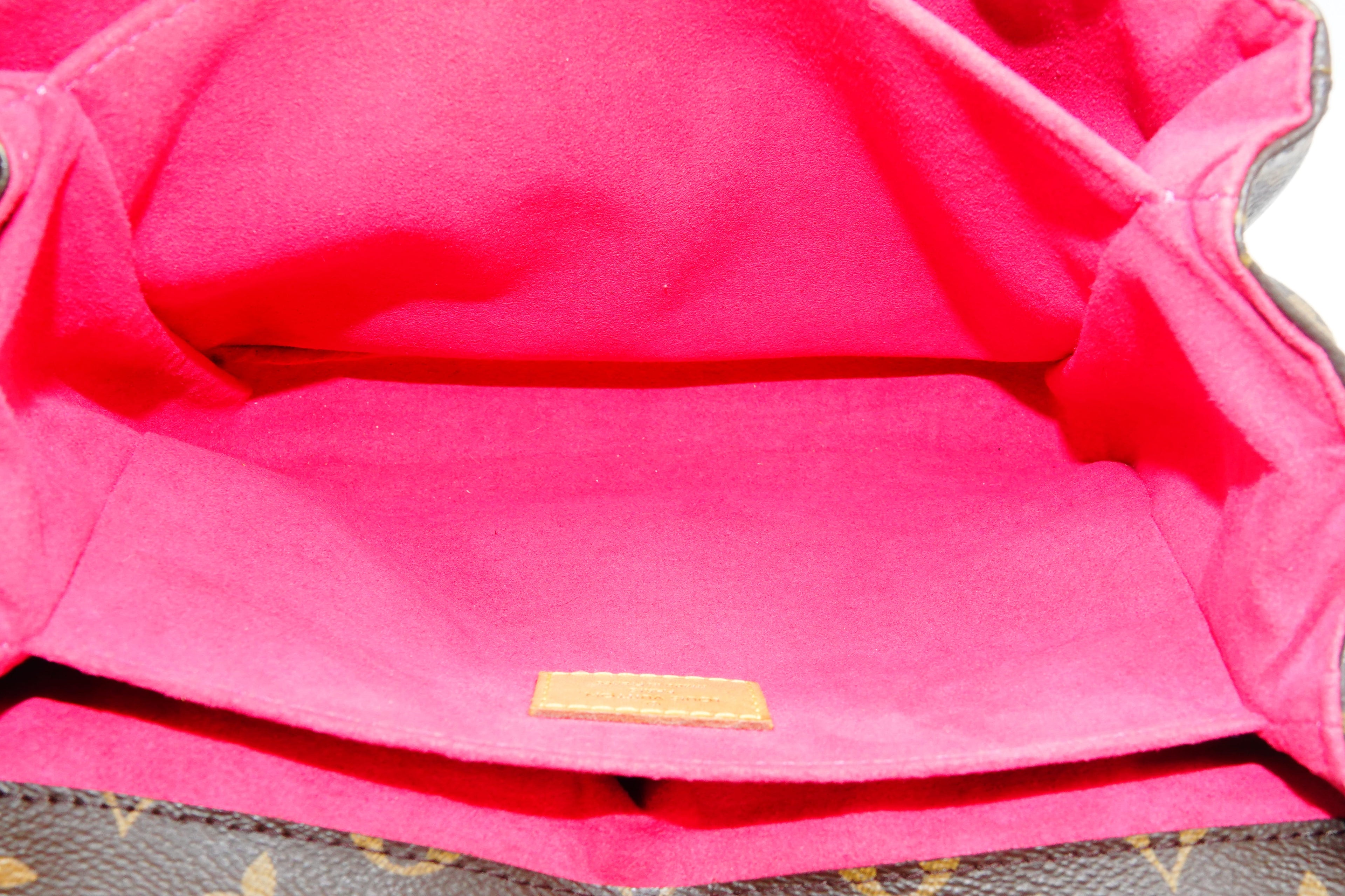 Close-up of a pink fabric with a gold label on a textured surface