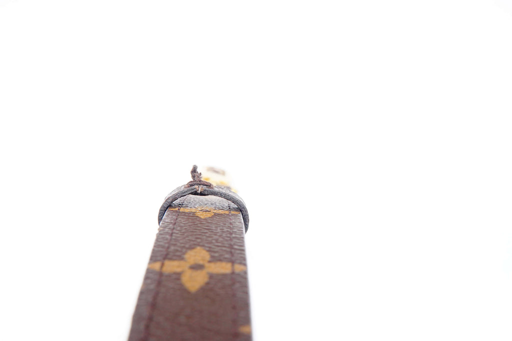Close-up of a brown leather product with a gold emblem on a white background