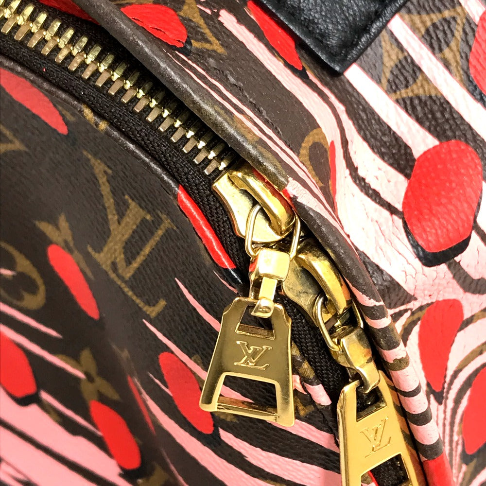 Close-up of a patterned handbag with gold zipper pull and visible brand logo.