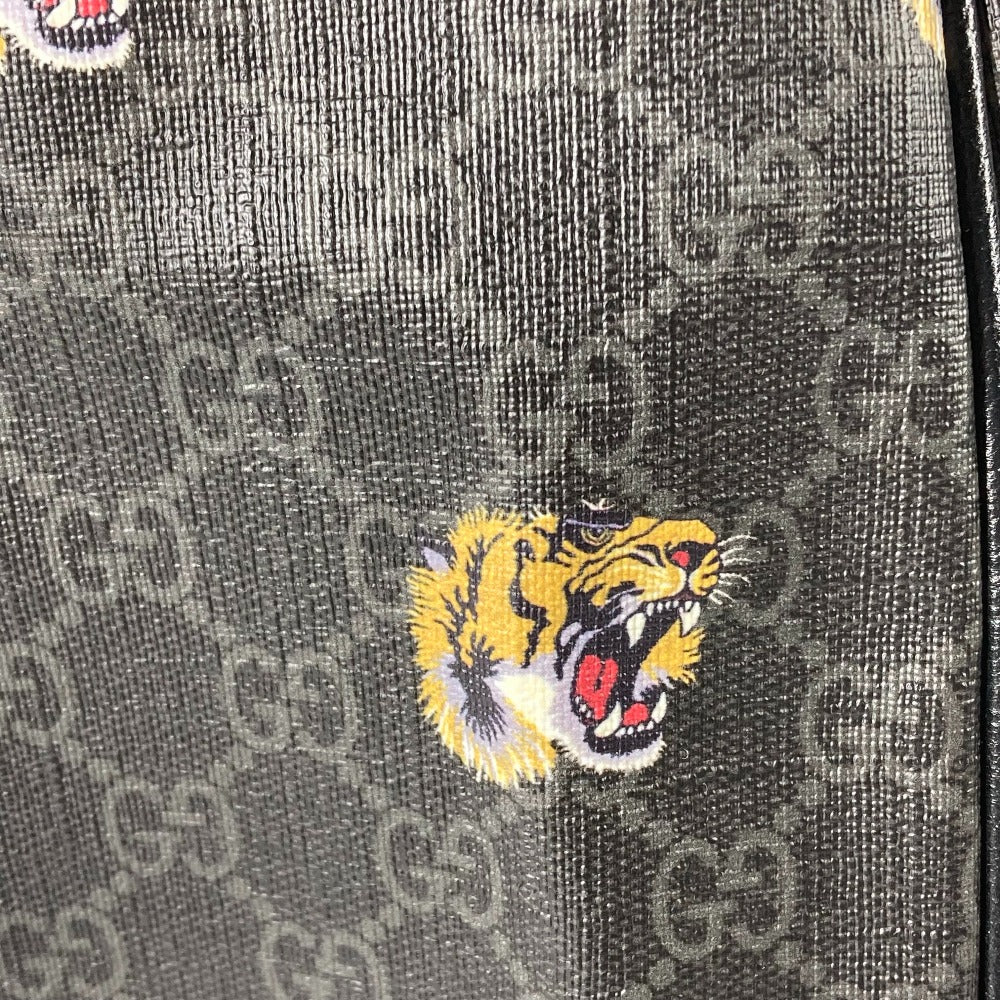 Close-up of a textured surface with a tiger emblem and Gucci logo pattern.