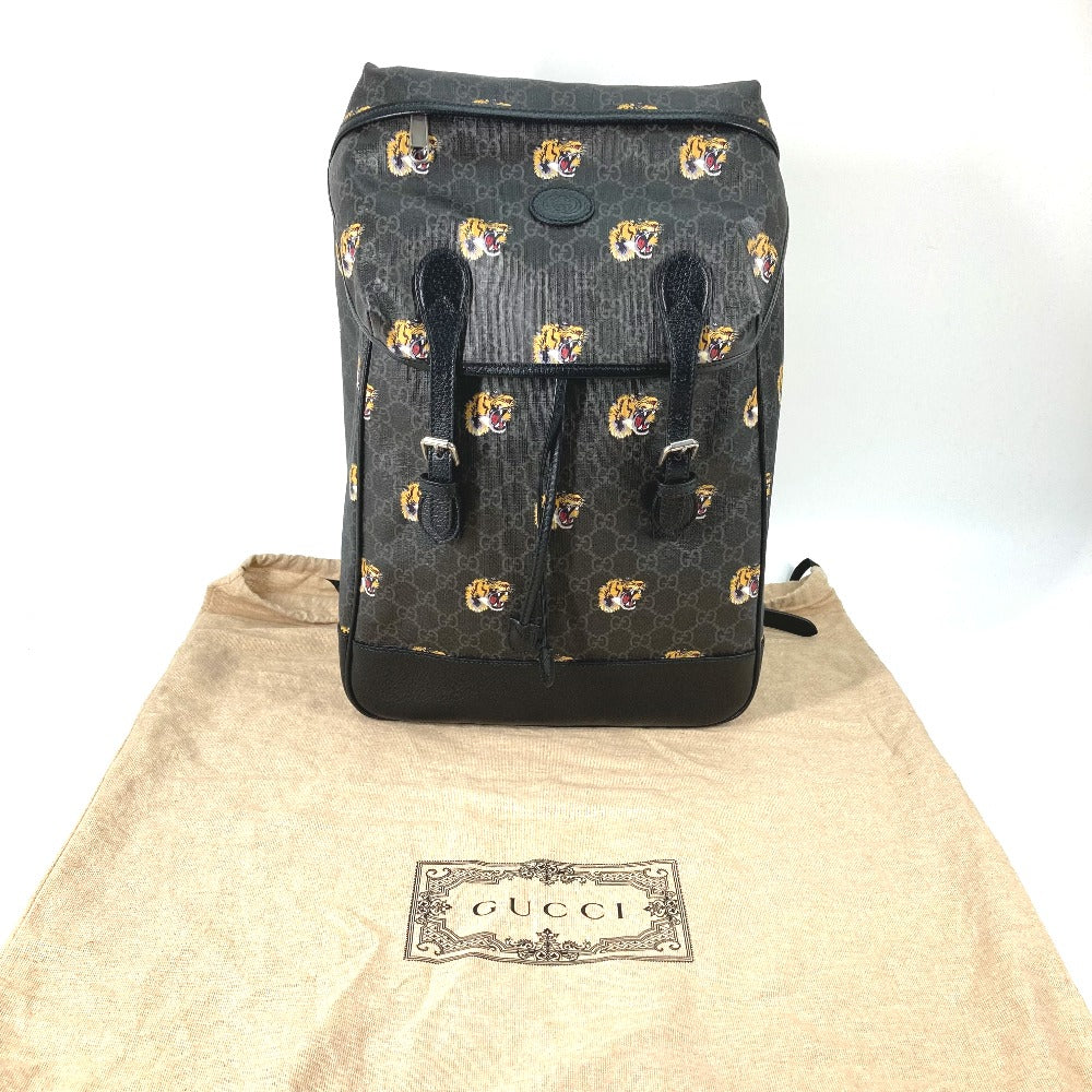 Black backpack with tiger pattern on a Gucci branded cloth background