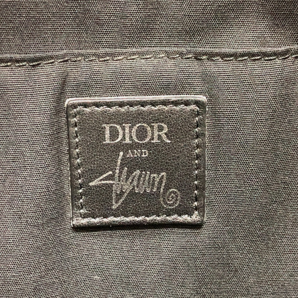Dior and Stussy label on a textured surface
