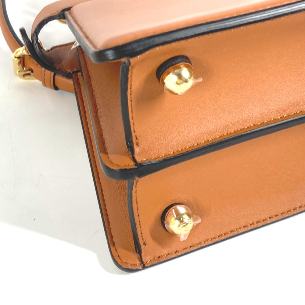 Close-up of a brown leather handbag with gold accents on a white background