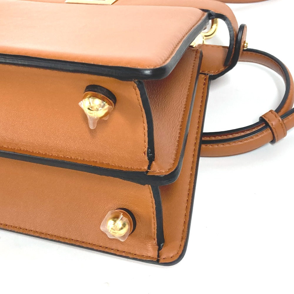 Brown leather handbag with gold accents on a white background