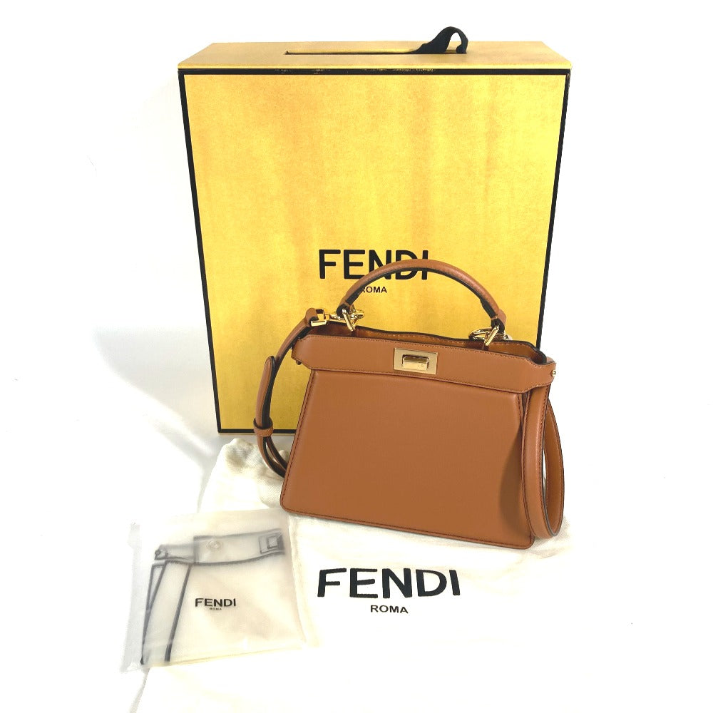 Brown Fendi handbag with yellow Fendi box and white dust bag on a white background