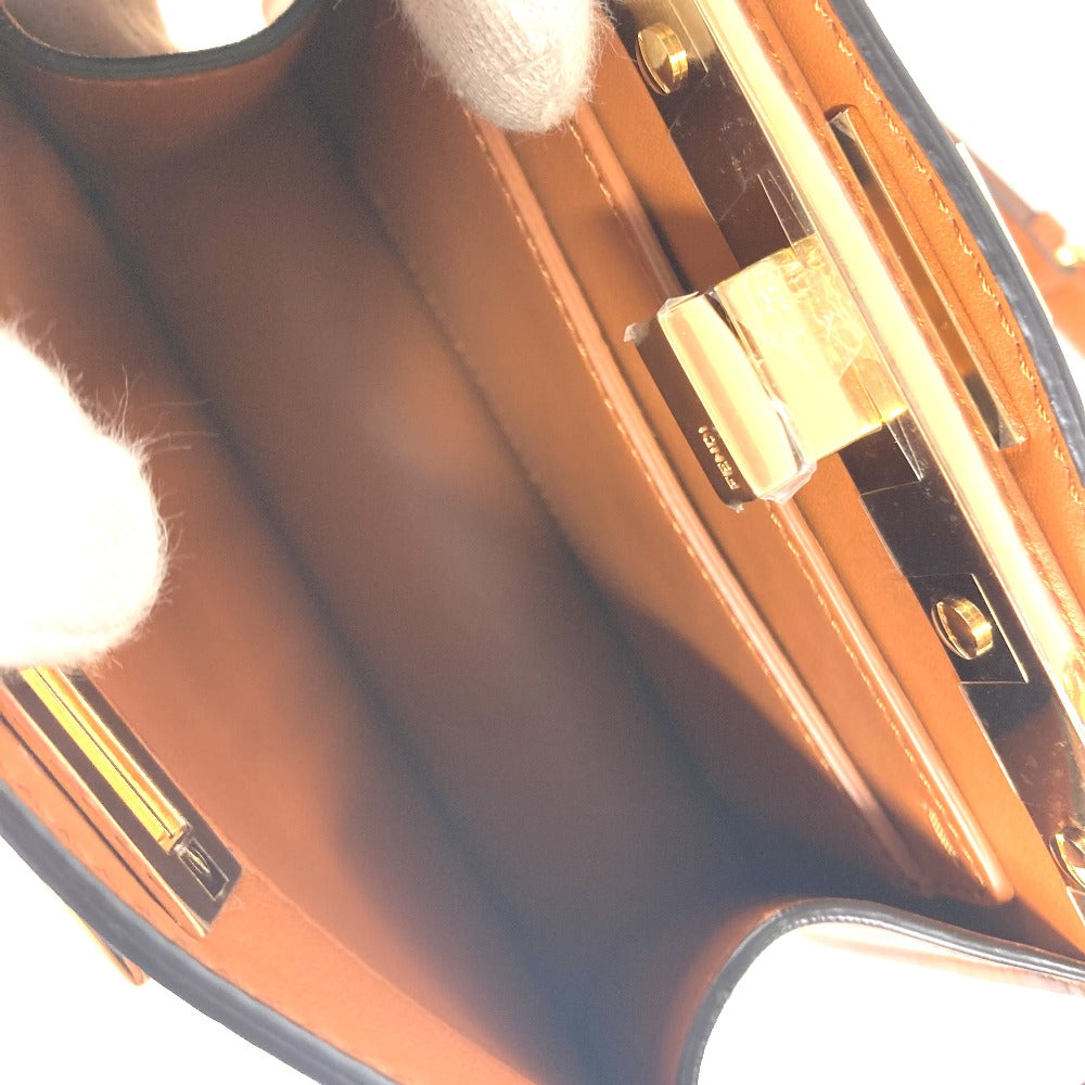 Close-up of a brown leather suitcase with gold hardware on a white background