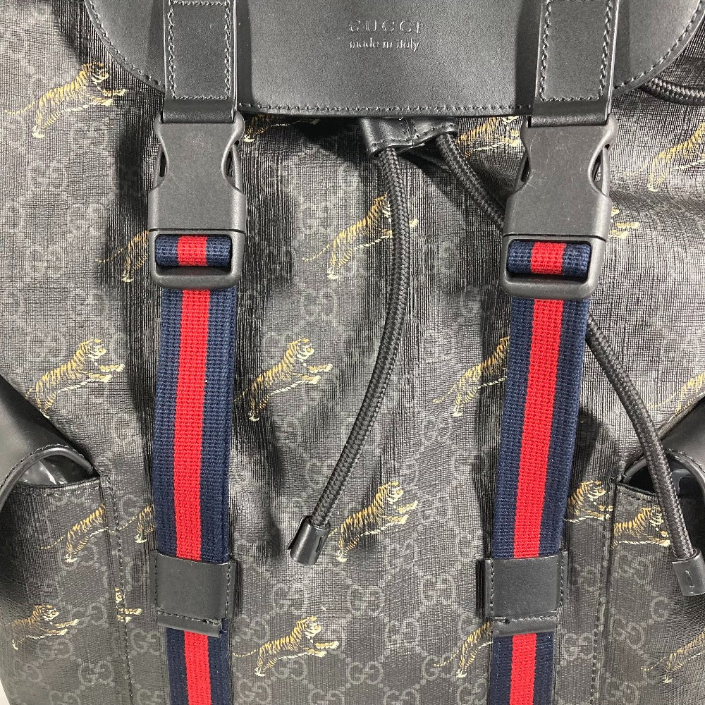 Close-up of a Gucci backpack with tiger pattern and red and blue straps.