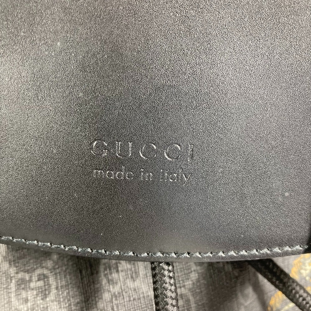Close-up of a Gucci logo on a black leather product with 'made in Italy' text.