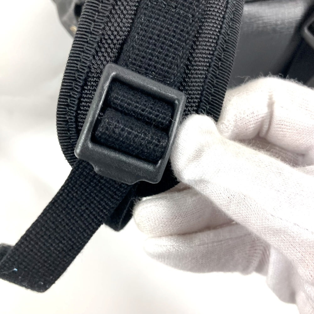 Black strap with buckle held by a gloved hand on a white background
