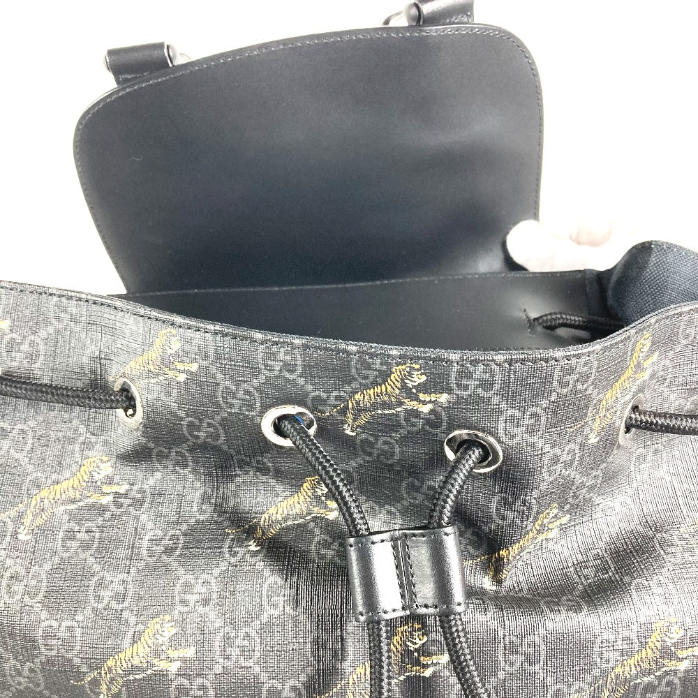 Close-up of a gray handbag with a pattern and visible brand logo.