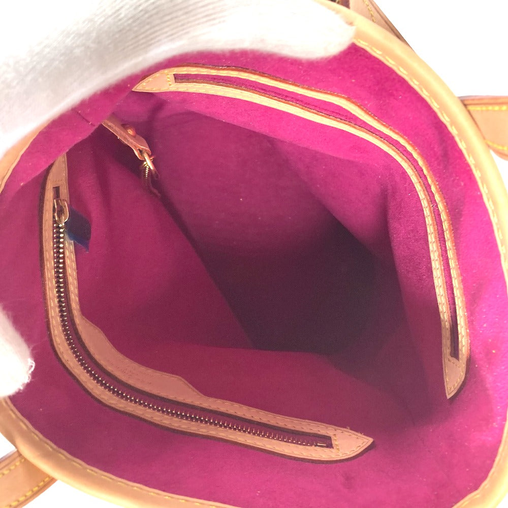Close-up of a pink bag with gold zipper and trim.
