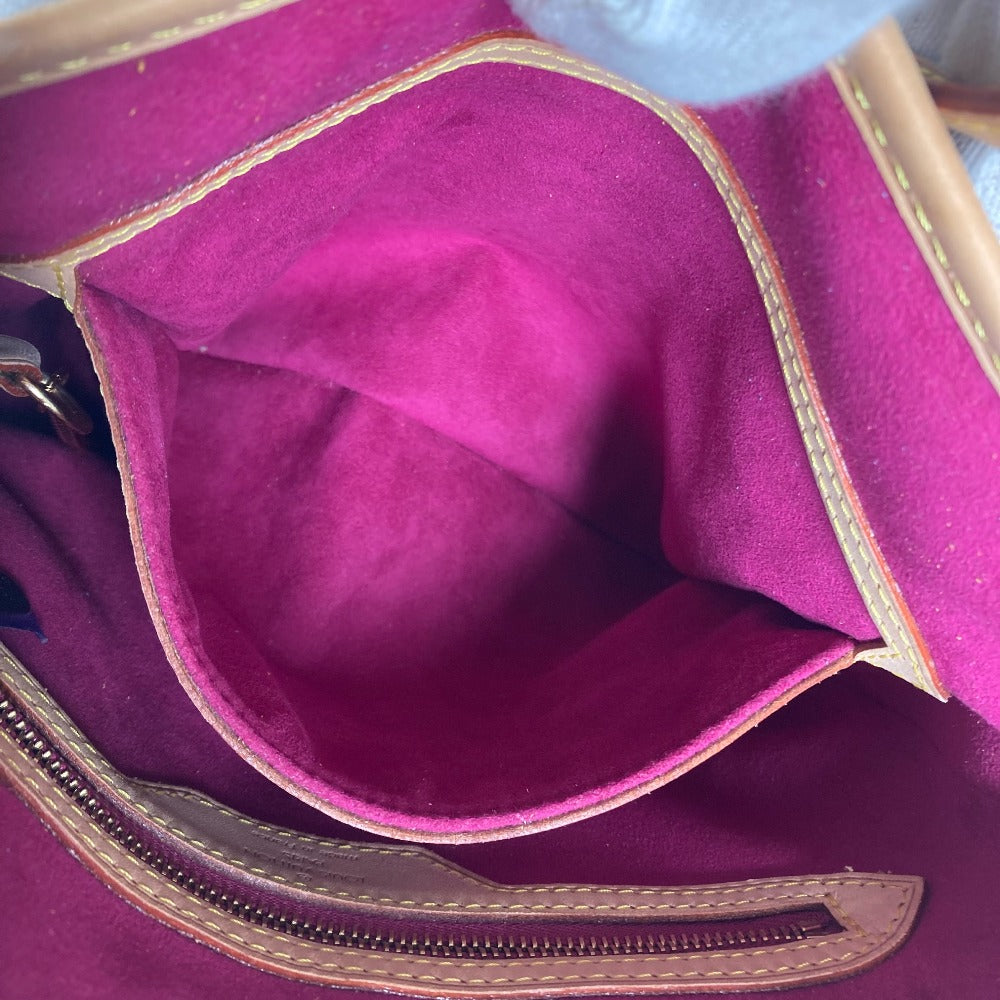 Close-up of a purple bag with gold trim and stitching.