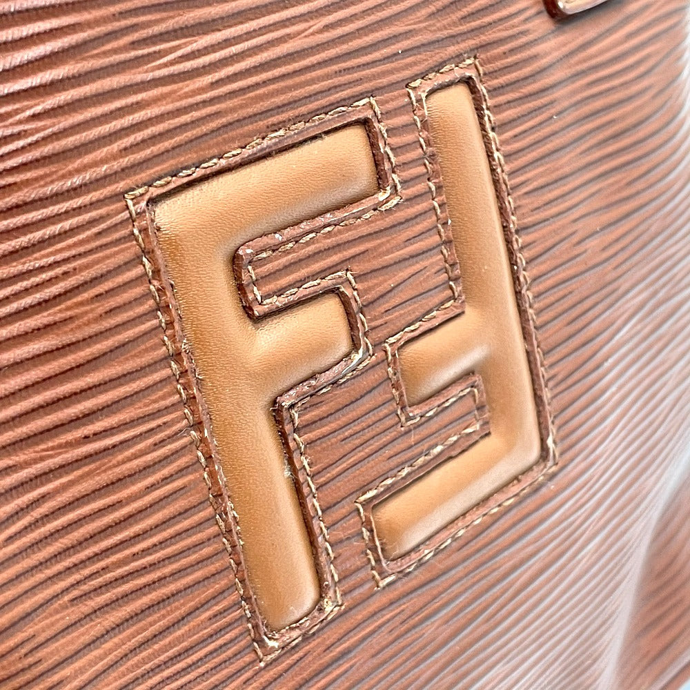 Close-up of a brown leather logo on a textured surface
