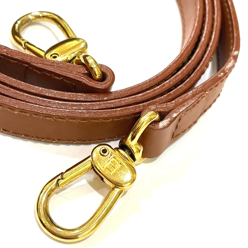 Brown leather strap with gold hardware on a white background
