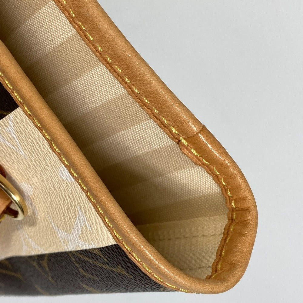 Close-up of a handbag with brown leather trim on a light gray background