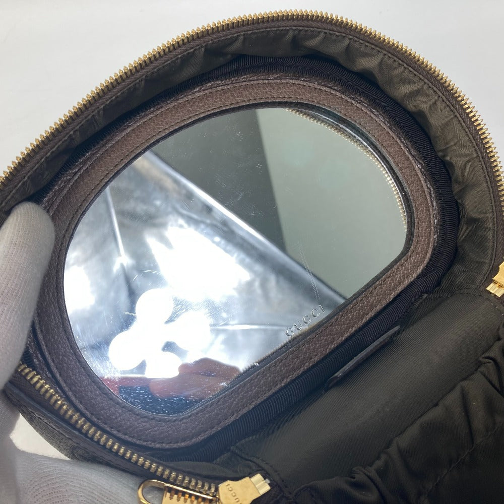 Round mirror inside a black case with gold zipper