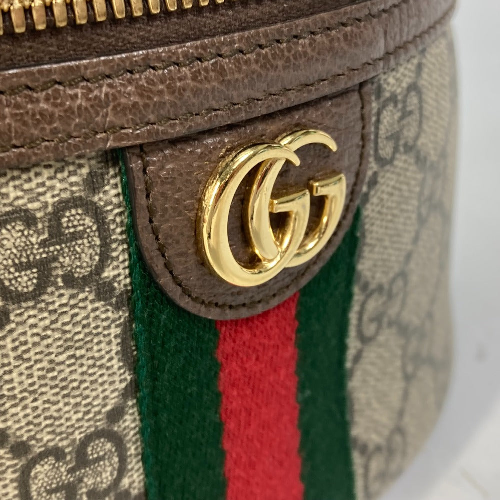 Close-up of a Gucci handbag with gold logo and iconic green and red stripes.
