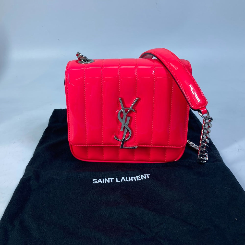 Red YSL handbag on a black Saint Laurent shirt with a light gray background