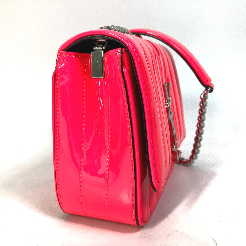 Shiny pink handbag with a chain detail on a light background