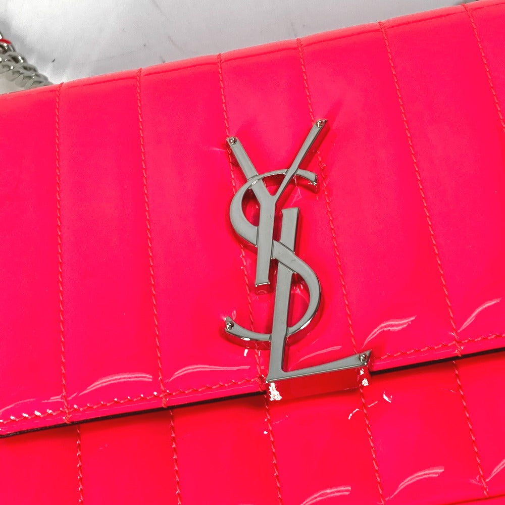 Close-up of a red handbag with a silver logo on a white background