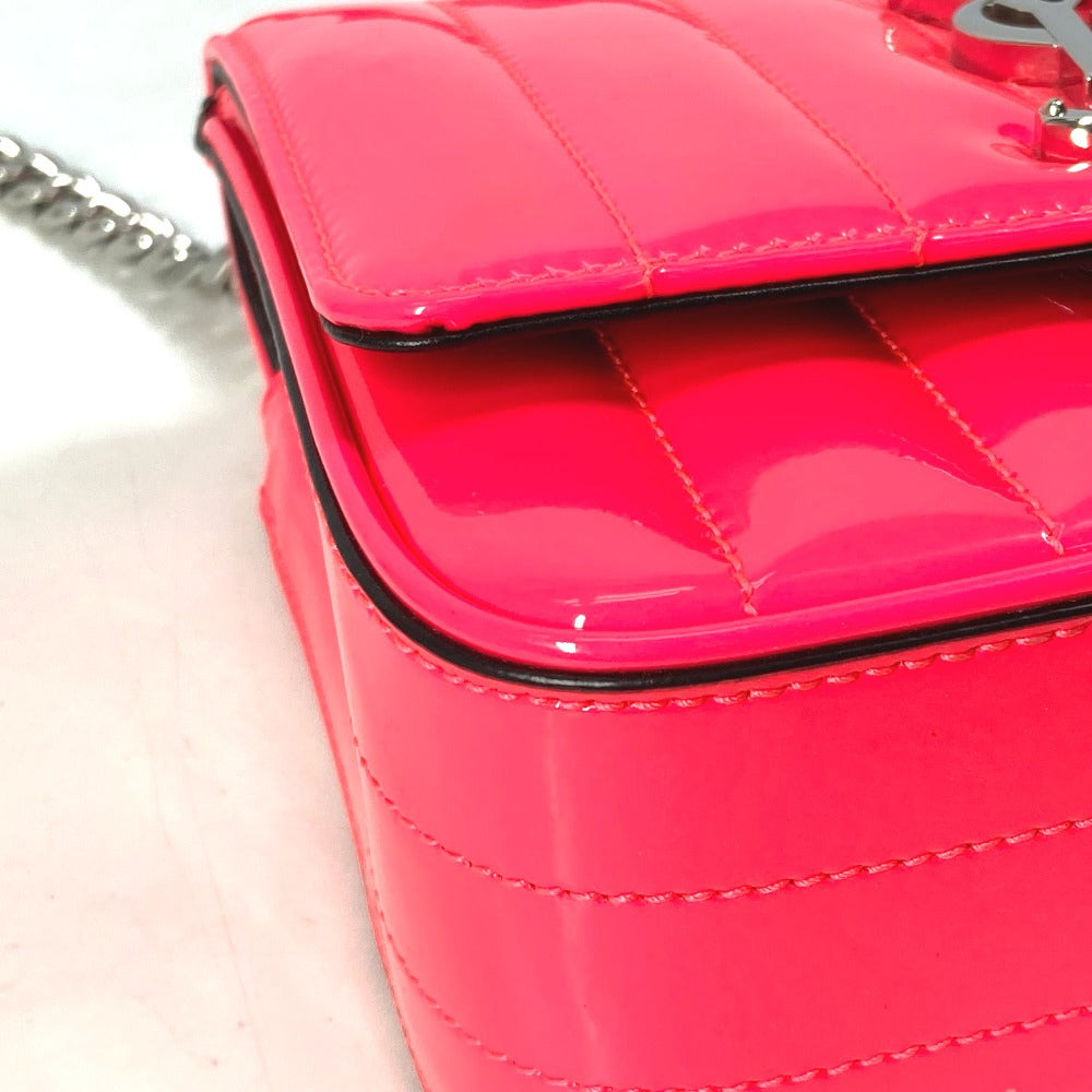 Close-up of a pink quilted handbag with a chain strap on a white background