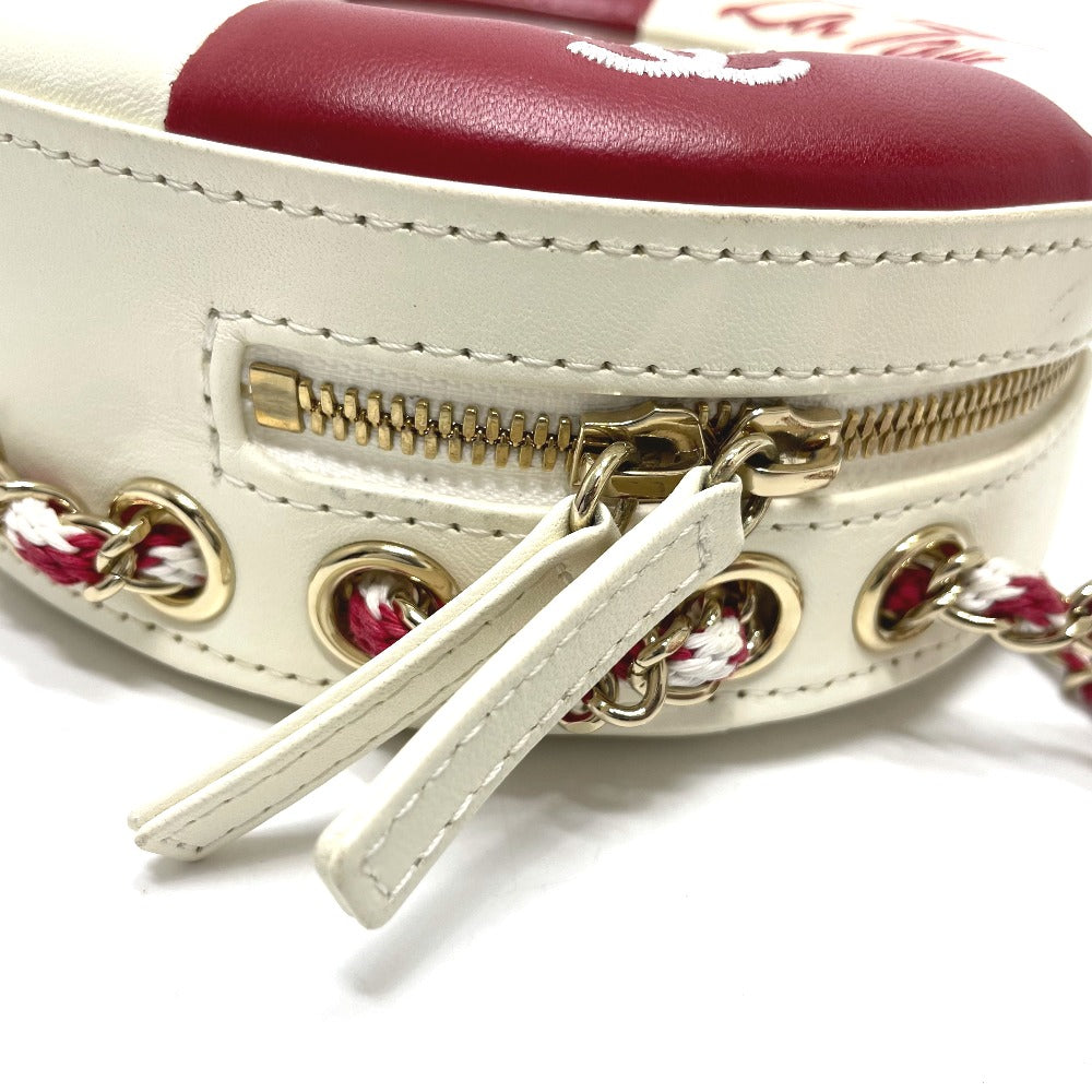 Close-up of a white handbag with gold accents and red interior on a white background
