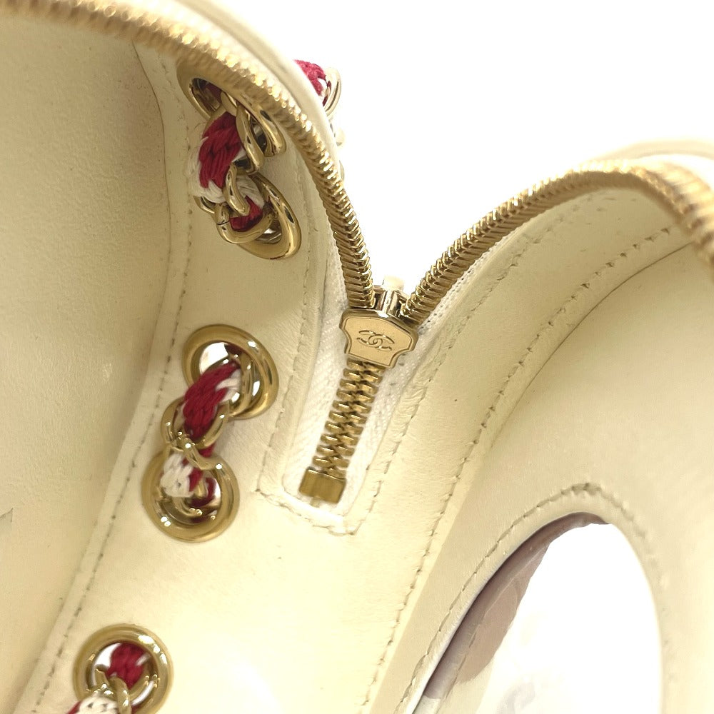 Close-up of a beige shoe with gold zipper and decorative elements on a white background
