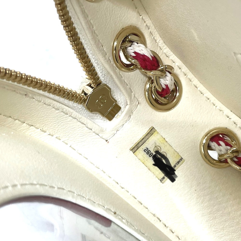 Close-up of a cream-colored handbag with gold hardware and a visible brand tag.