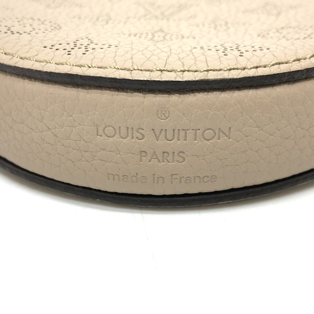 Close-up of Louis Vuitton logo on a beige leather product.