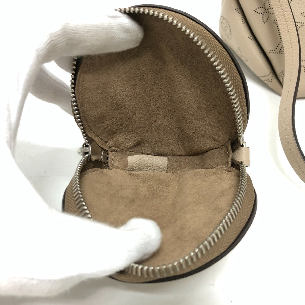 Close-up of a beige handbag with a white glove on a white background