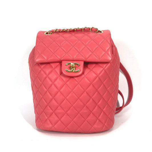 Pink quilted handbag with gold hardware on a white background