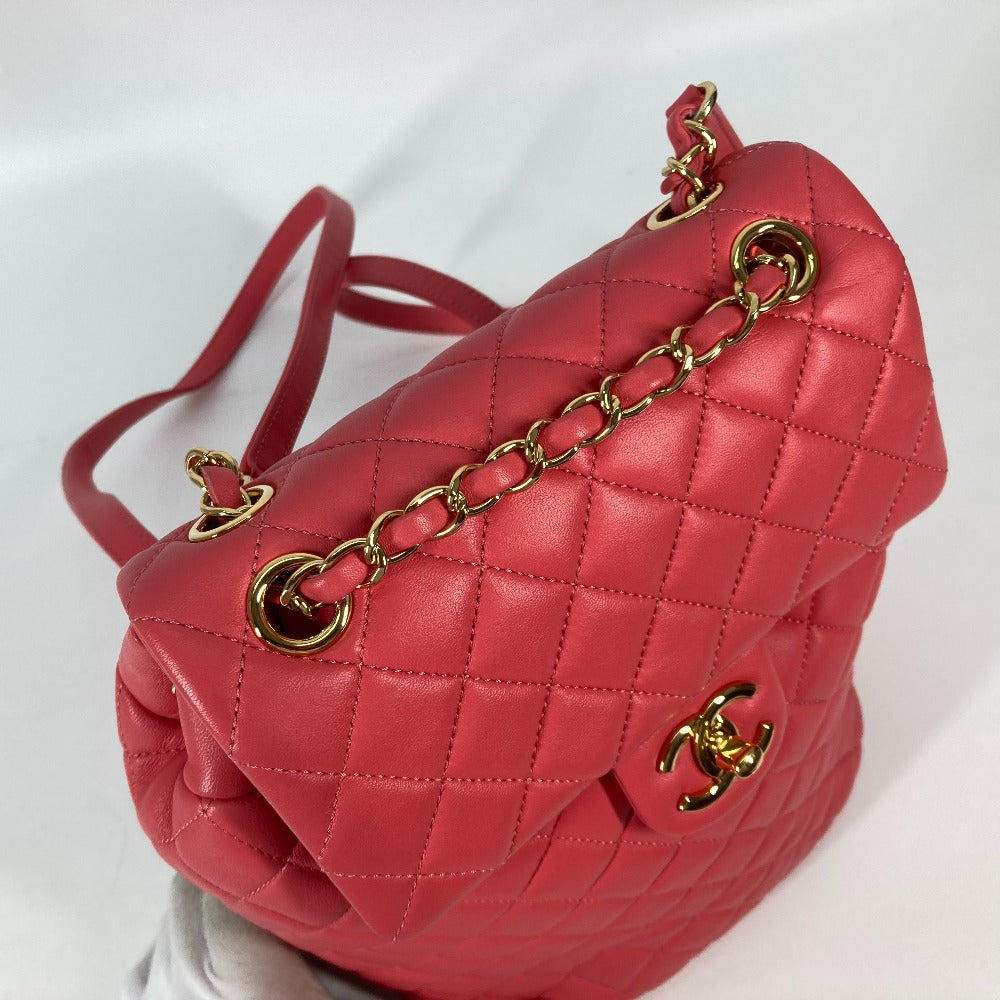 Red quilted handbag with gold chain and clasp on a white background