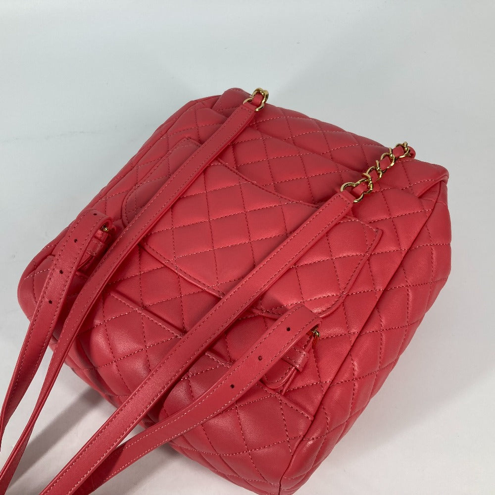 Red quilted handbag with a gold chain on a light gray background