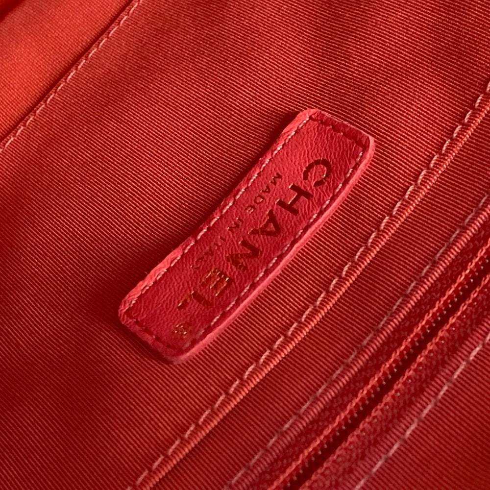 Close-up of a red fabric with a brand logo embroidered on it.