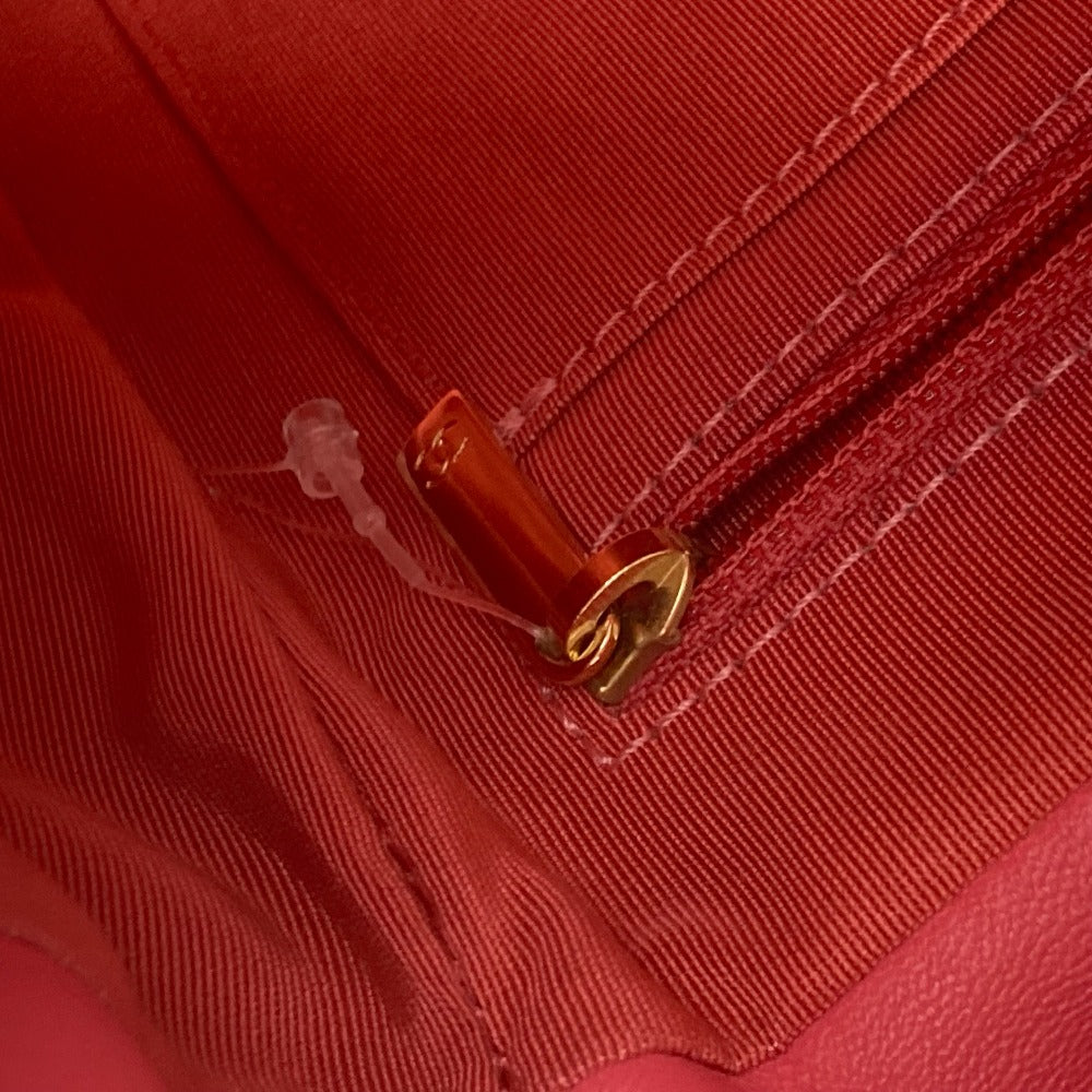 Close-up of a red fabric with a zipper and gold pull tab.