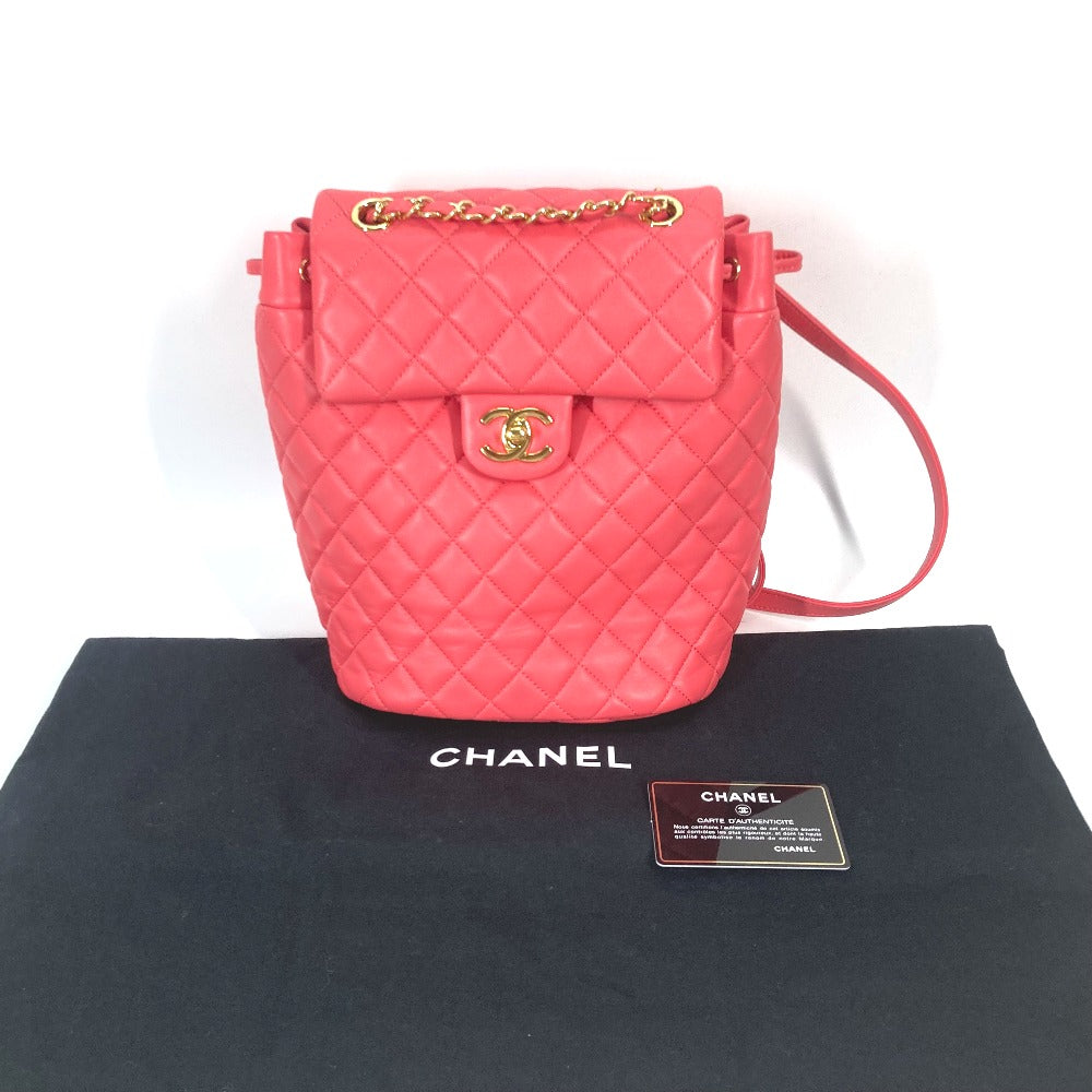 Pink quilted handbag with gold hardware on a Chanel branded black cloth