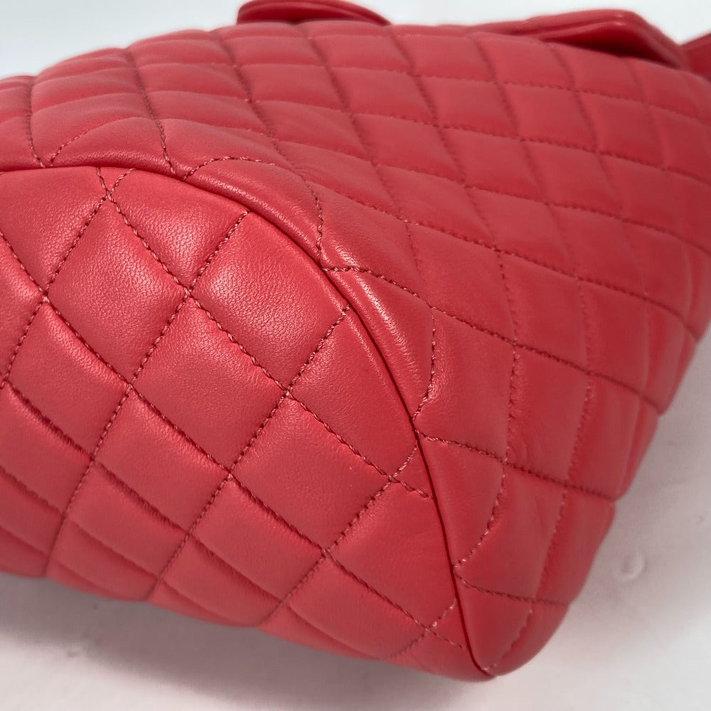 Close-up of a red quilted handbag on a light gray background