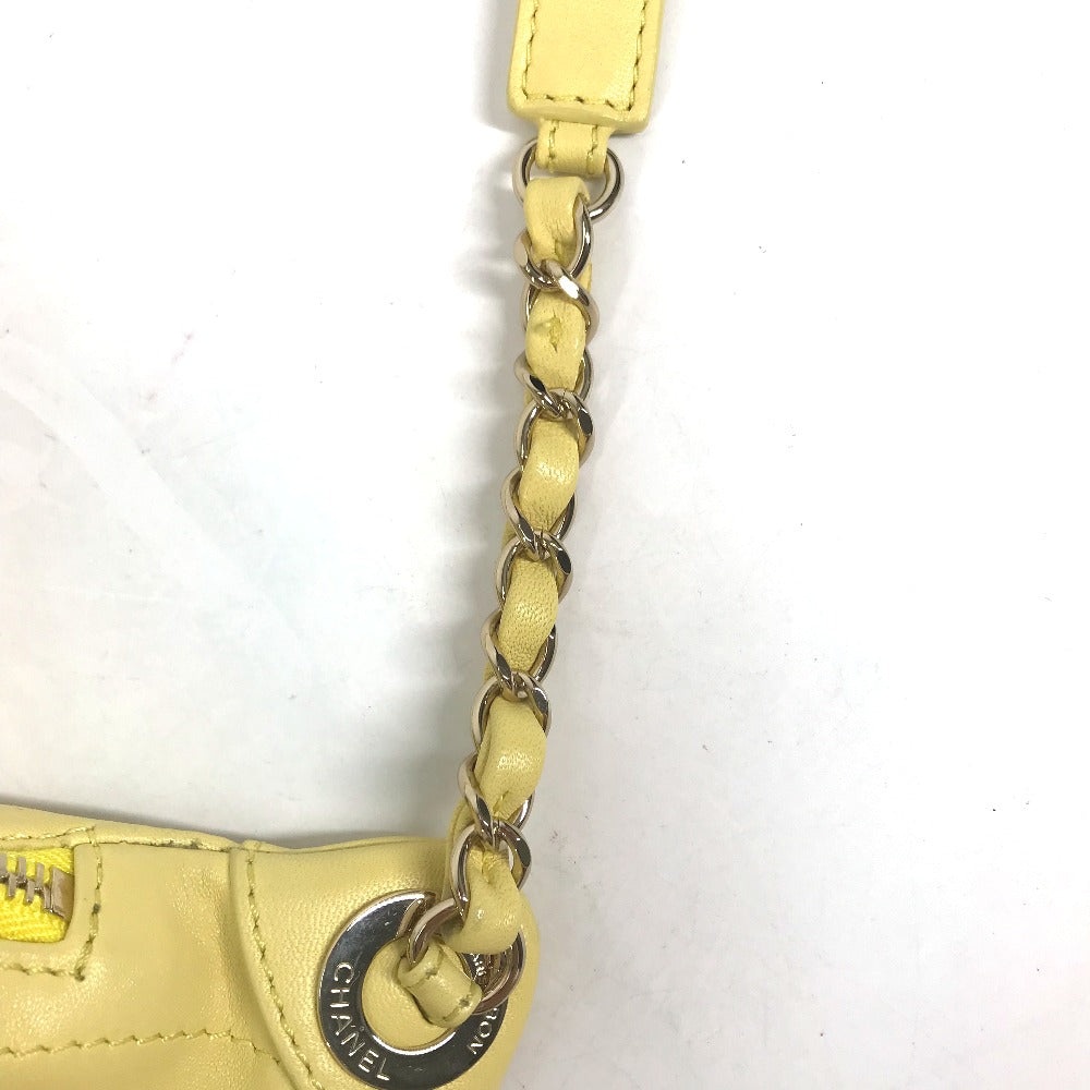 Close-up of a yellow handbag with a chain strap on a white background