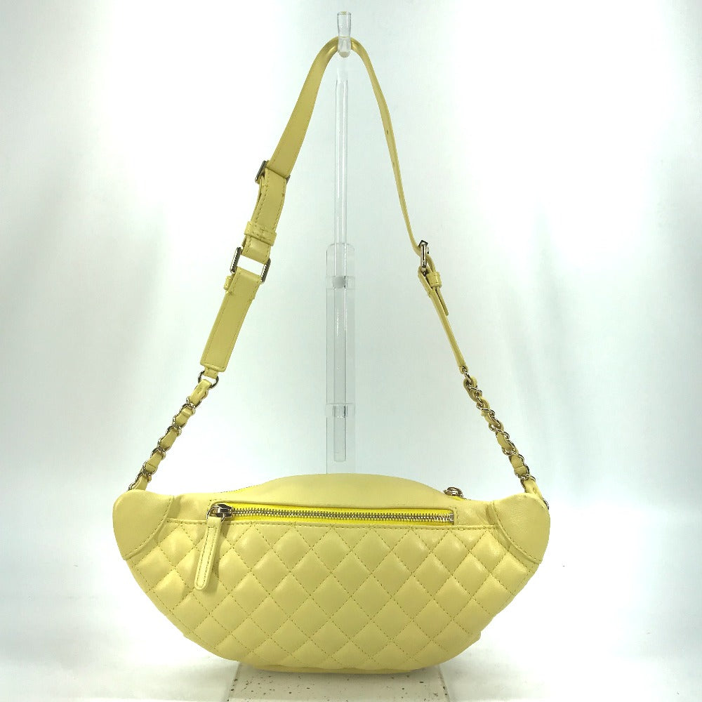 Yellow quilted handbag with a strap on a white background