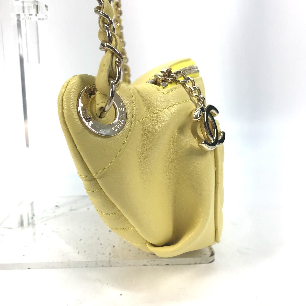 Yellow heart-shaped purse with a chain strap on a white background