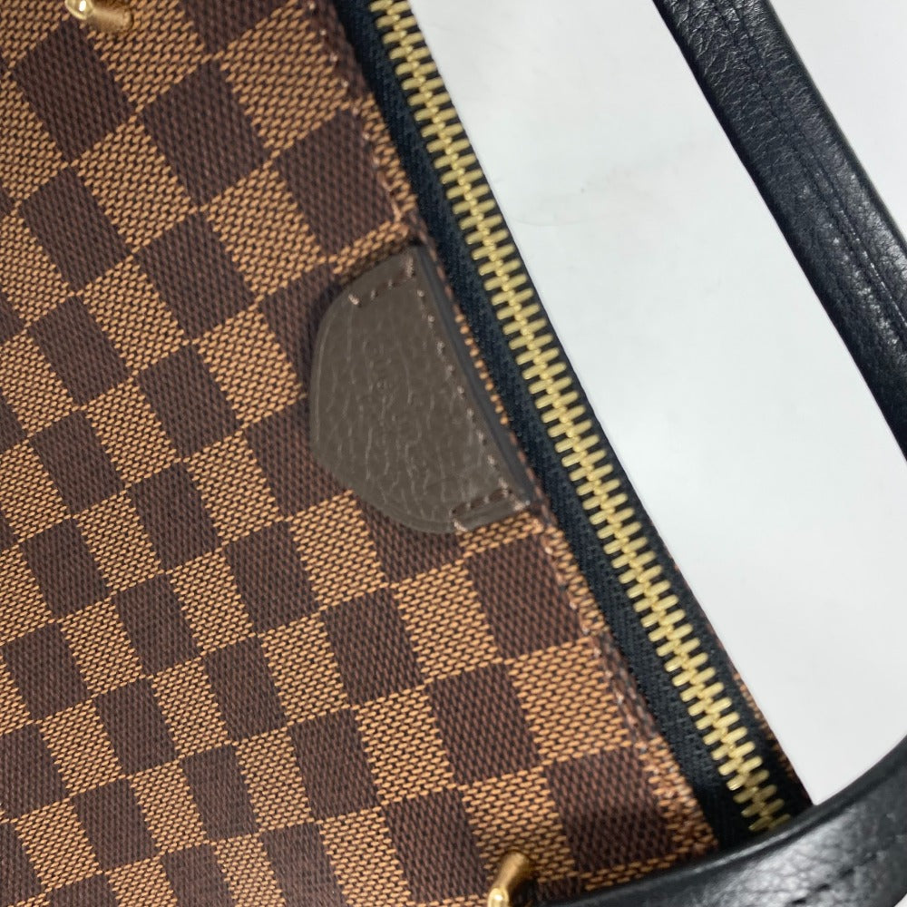 Close-up of a checkered patterned bag with a gold zipper.