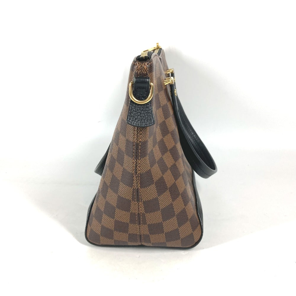Brown checkered handbag with black strap on a white background