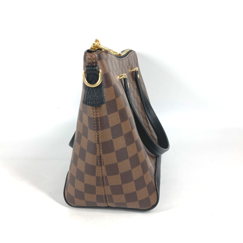 Brown checkered handbag with gold accents on a white background