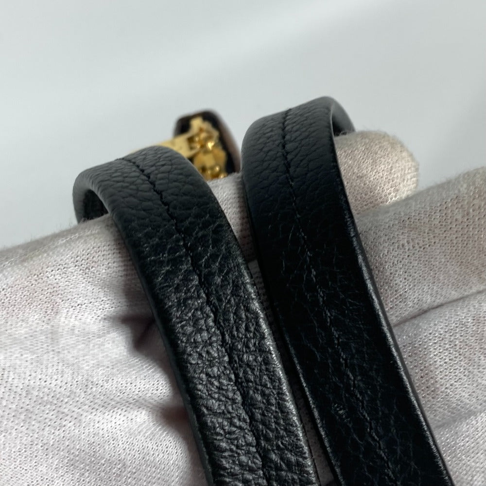 Close-up of two black leather bracelets on a textured surface with a neutral background